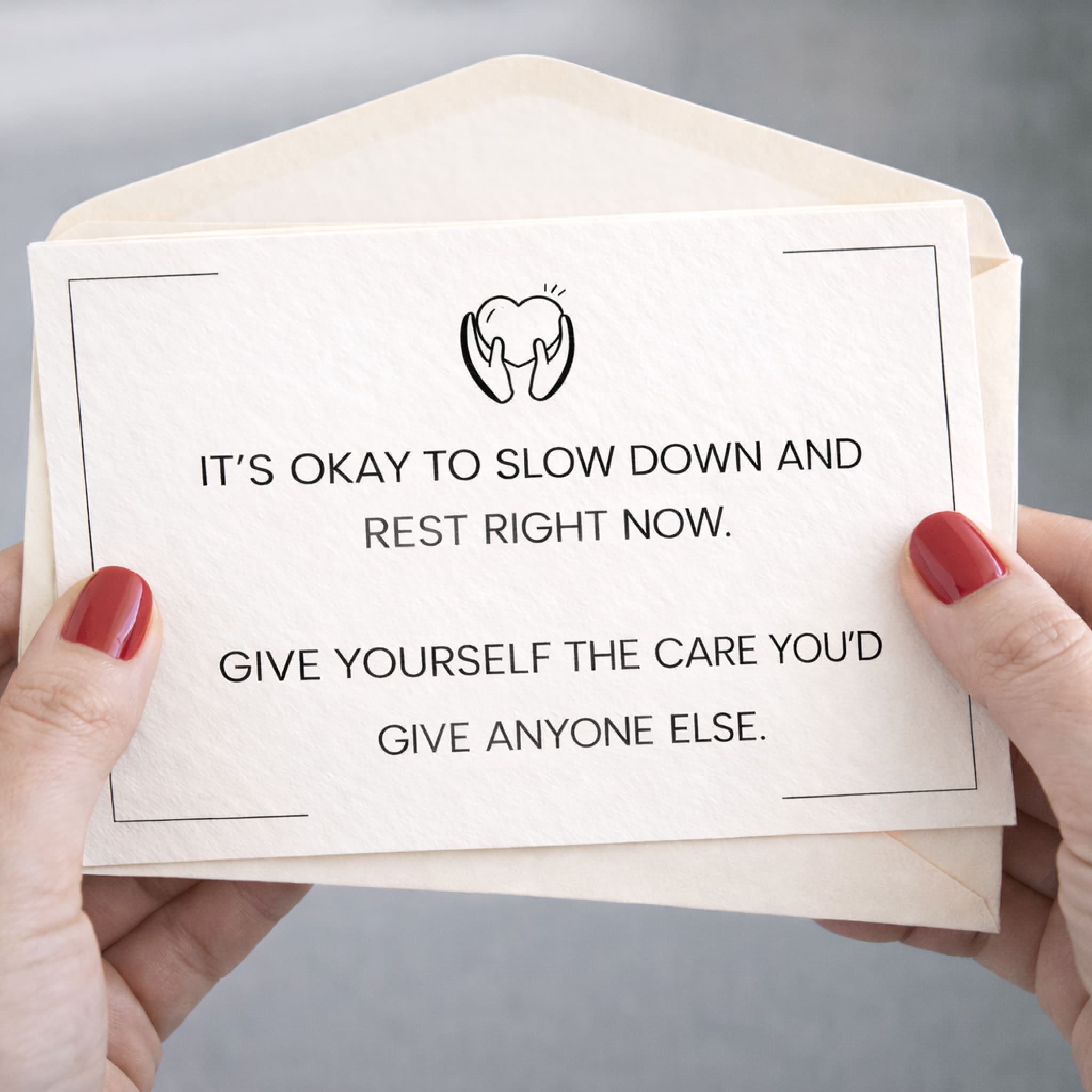 Card with motivational message held by hands against a neutral background