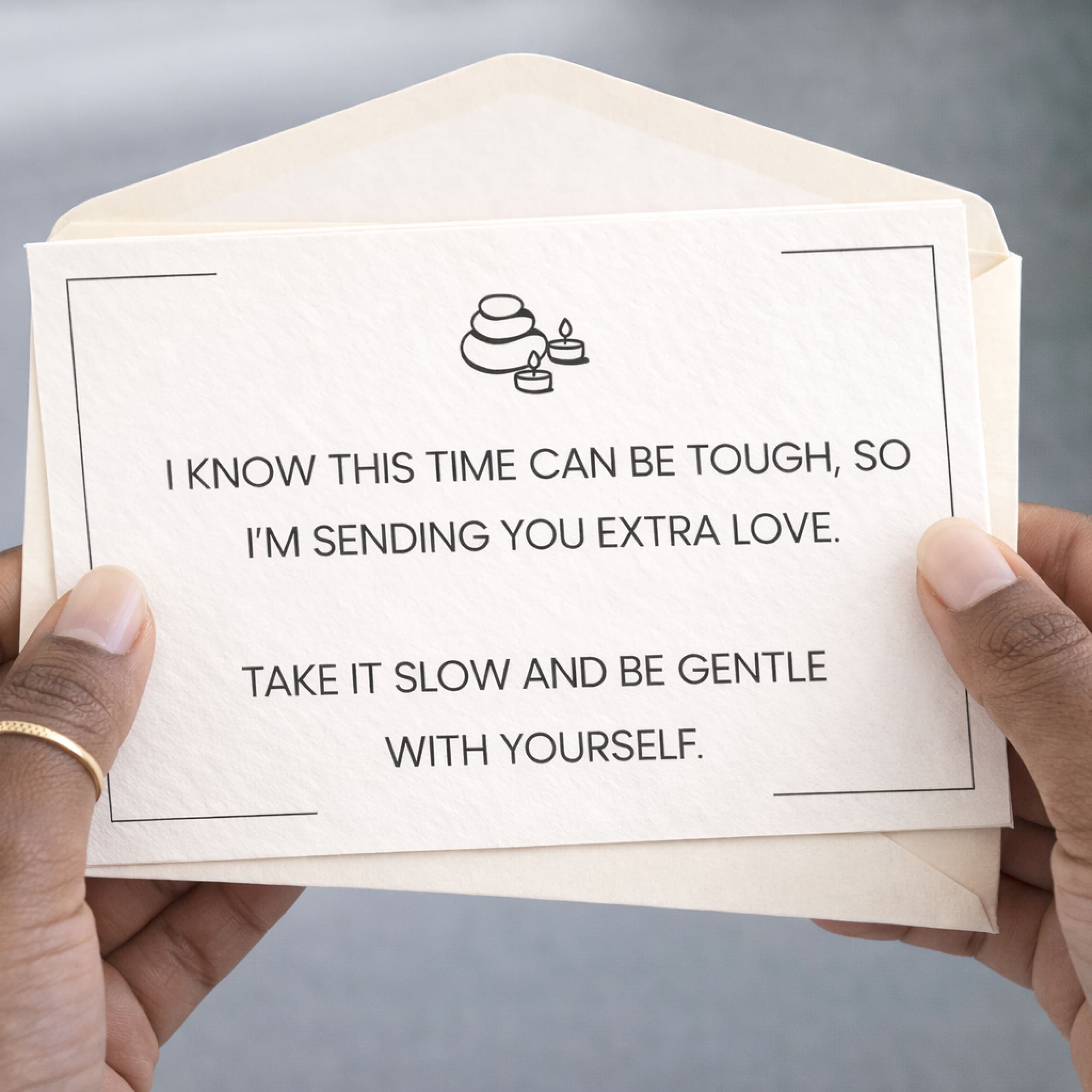 Card with message of support held by a person, with a neutral background