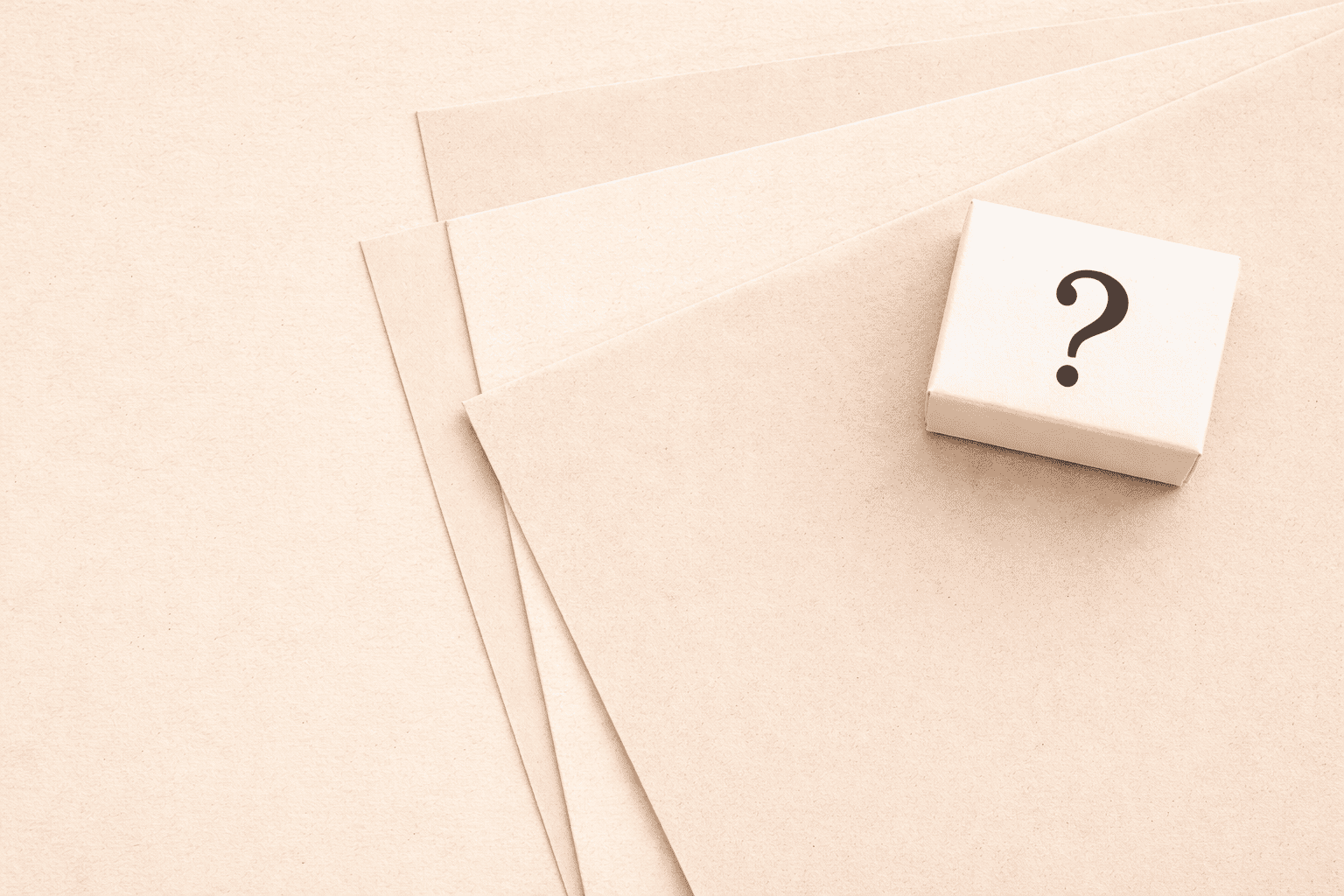 Small white block with a black question mark on a beige background