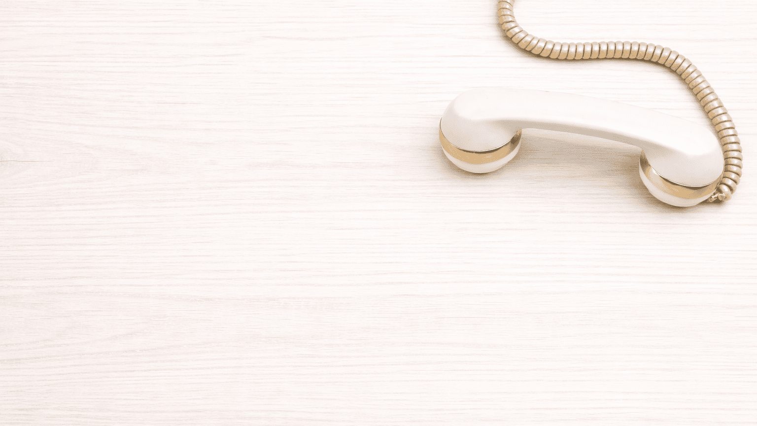 White phone receiver on a light gray background